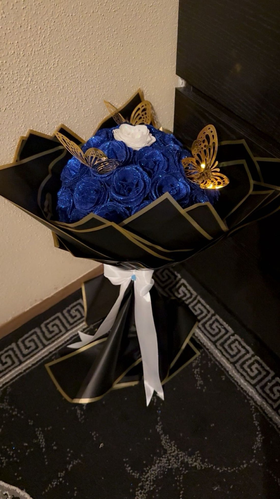 A bouquet in a glossy dark blue and black color with butterflies